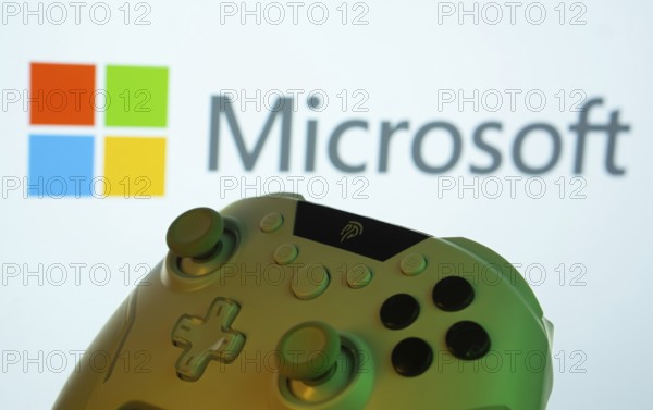 Dhaka, Bangladesh- 14 Nov 2025: A close-up of a gamepad with the Microsoft seen on screen in the background