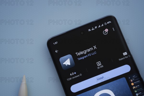 Dhaka, Bangladesh- 29 May 2025: On a blue surface, a smartphone displays the Telegram X app within the Google Play Store