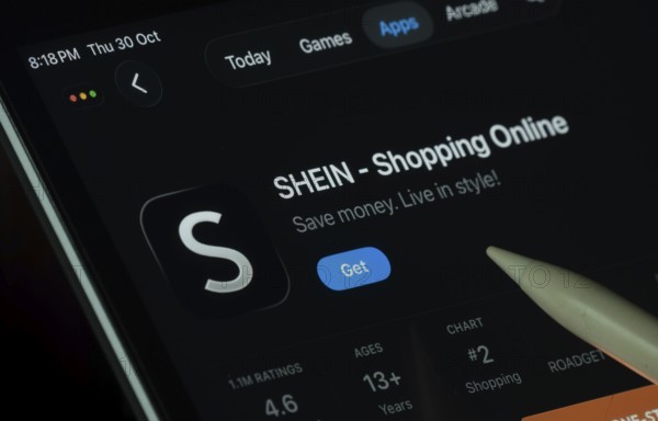 Dhaka, Bangladesh- 30 Oct 2025: SHEIN app displayed on a iPad screen in dark mode with a digital pen pointing at it