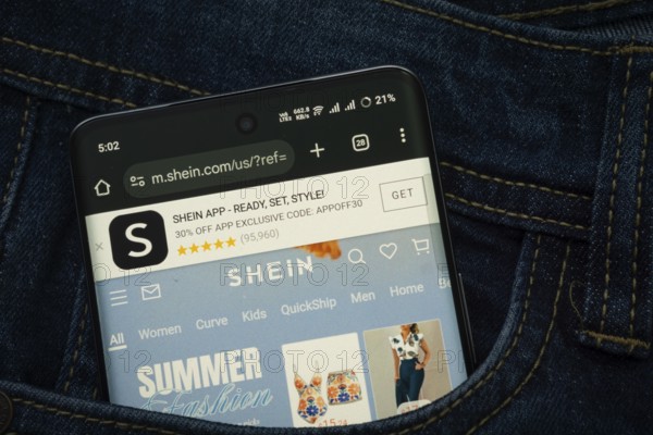 Dhaka, Bangladesh- 15 June 2025: A smartphone displaying the SHEIN web interface peeks out of a denim pocket