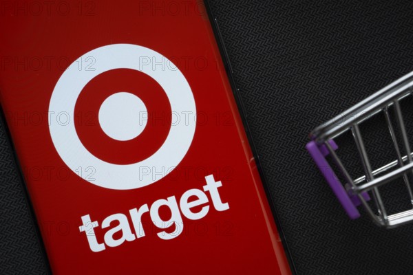 Dhaka, Bangladesh- 03 July 2025: A smartphone displaying the Target logo next to a miniature shopping cart on a background