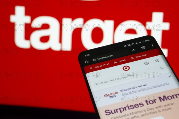 Dhaka, Bangladesh- 03 July 2025: Smartphone displaying Target web interface against Target logo background