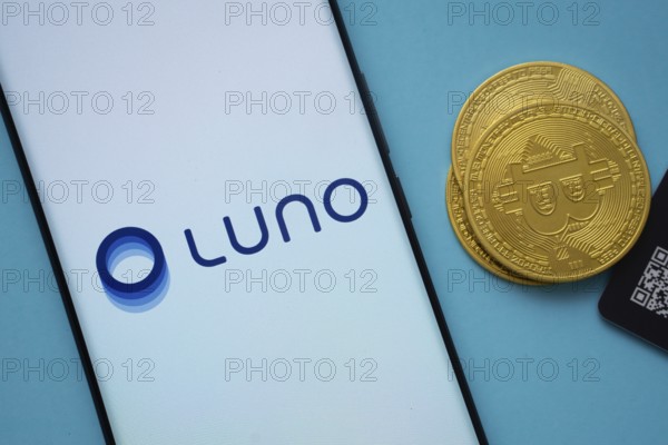 Dhaka, Bangladesh- 03 Sep 2025: Luno logo on smartphone screen near Bitcoin coin and QR code on blue background