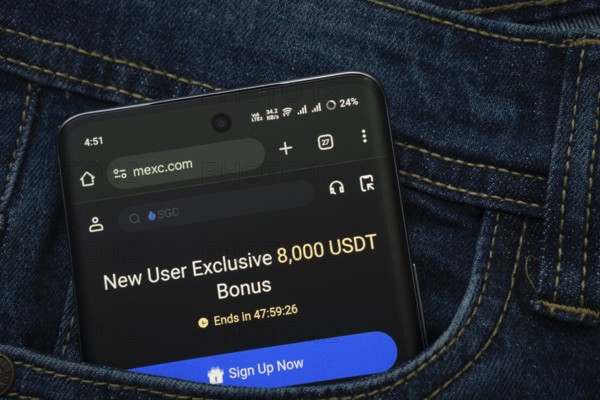 Dhaka, Bangladesh- 15 June 2025: A smartphone displaying the MEXC web interface peeks out of a denim pocket