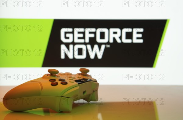 Dhaka, Bangladesh- 14 Nov 2025: A close-up of a white gamepad with the Geforce Now seen on screen in the background
