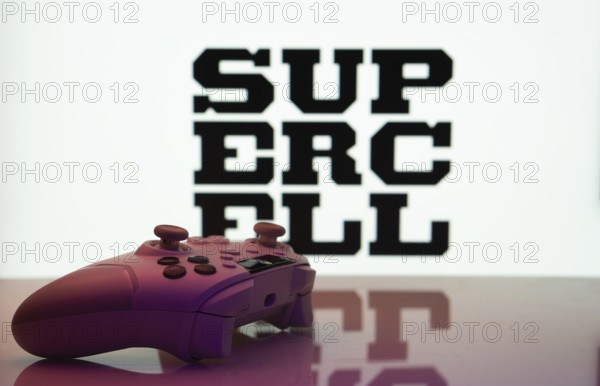 Dhaka, Bangladesh- 14 Nov 2025: A close-up of a white gamepad with the Supercell seen on screen in the background