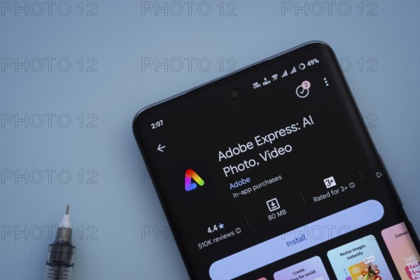Dhaka, Bangladesh- 29 May 2025: On a blue surface, a smartphone displays the Adobe Express app within the Google Play Store