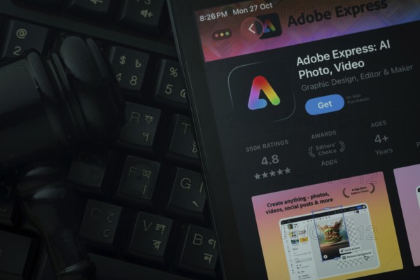 Dhaka, Bangladesh- 28 Oct 2025: An iPad displaying the Adobe Express app against a judge's gavel and dark keyboard background