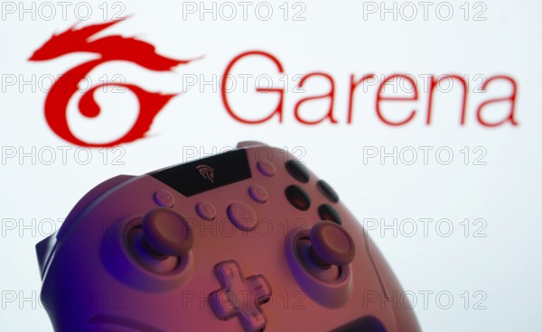 Dhaka, Bangladesh- 14 Nov 2025: A close-up of a gamepad with the Garena seen on screen in the background
