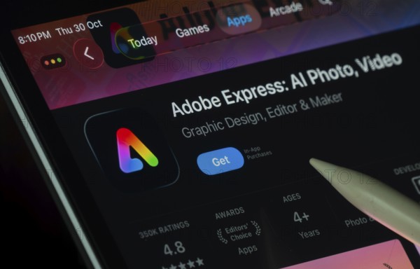 Dhaka, Bangladesh- 30 Oct 2025: Adobe Express app displayed on a iPad screen in dark mode with a digital pen pointing at it