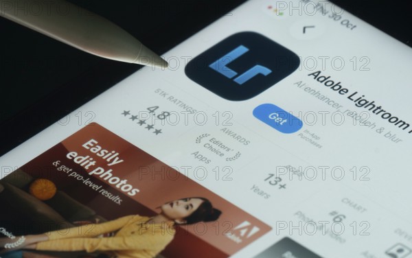 Dhaka, Bangladesh- 30 Oct 2025: Adobe Lightroom app on a iPad screen with a pen pointing at the install option