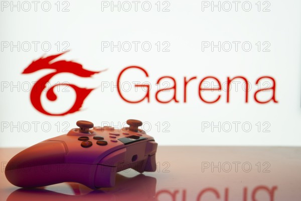 Dhaka, Bangladesh- 19 Sep 2025: A close-up of a white gamepad with the Garena seen on screen in the background
