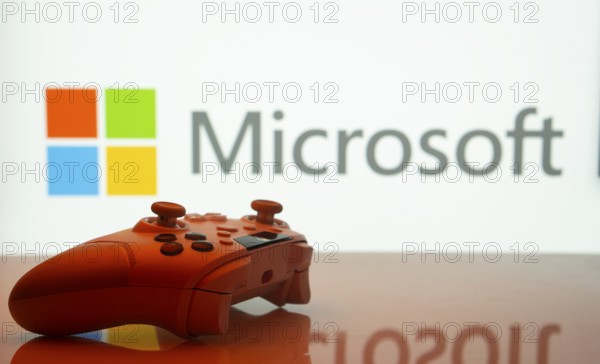 Dhaka, Bangladesh- 09 May 2025: A close-up of a white gamepad with the Microsoft seen on screen in the background