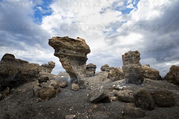 Eroded rock formations in volcanic landscape with dramatic cloudy skies, Ciudad Estratificada or Los Roferos, Antigua Rofera de Teseguite, Lanzarote, Canary Islands, Spain