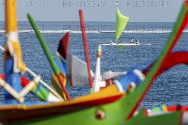 Colourfully painted outrigger fishing boats, (Junkung), on Sanur beach, Bali, Indonesia