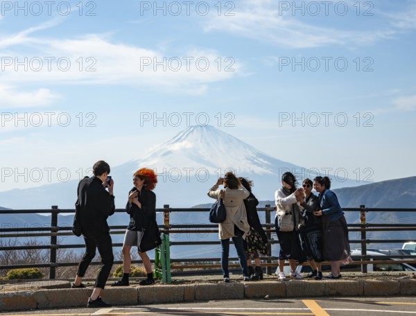 Tourists enjoy the view and take pictures, view of the snow-covered summit of Mount Fuji volcano in spring, Owakudani, Hakone, Japan