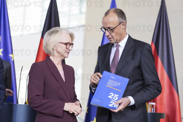 Prof. Dr. Monika Schnitzer (Chair of the Council of Experts) and Friedrich Merz (Federal Chancellor of the Federal Republic of Germany, CDU) handing over the 2025/2026 annual report entitled Creating prospects for tomorrow - do not squander opportunities from the Council of Experts to review macroeconomic development in the Federal Chancellery on 12.11.2025