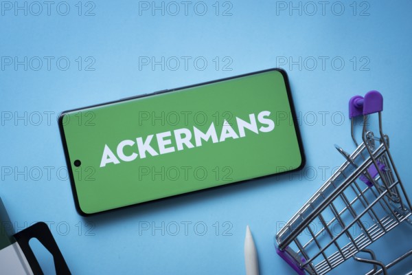 Dhaka, Bangladesh- 03 July 2025: Smartphone displaying Ackermans logo with shopping cart on a blue background