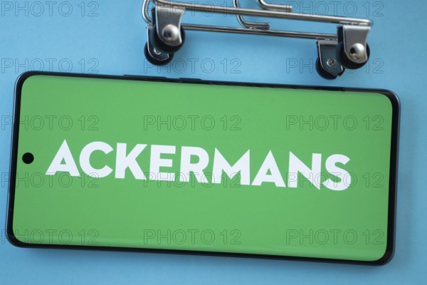 Dhaka, Bangladesh- 03 July 2025: Smartphone screen showing the Ackermans logo with shopping cart wheels on a blue background