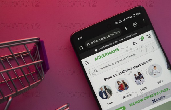 Dhaka, Bangladesh- 23 June 2025: A smartphone displaying the Ackermans website with a shopping cart is shown on a vibrant background