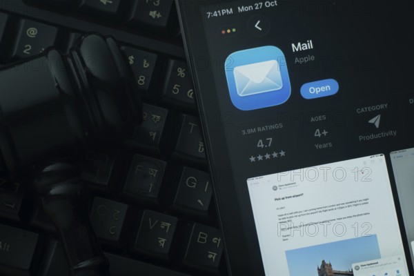 Dhaka, Bangladesh- 28 Oct 2025: An iPad displaying the Apple Mail app against a judge's gavel and dark keyboard background