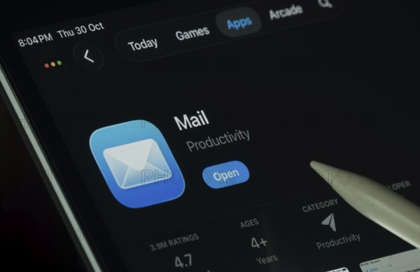 Dhaka, Bangladesh- 30 Oct 2025: Apple Mail app displayed on a iPad screen in dark mode with a digital pen pointing at it