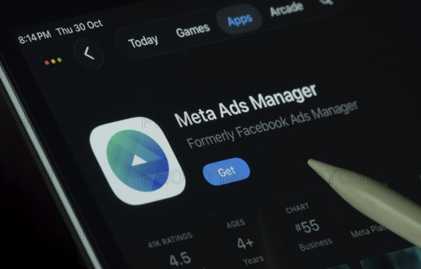 Dhaka, Bangladesh- 30 Oct 2025: meta ads manager app displayed on a iPad screen in dark mode with a digital pen pointing at it