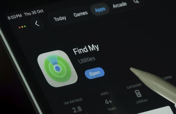 Dhaka, Bangladesh- 30 Oct 2025: Apple Find My app displayed on a iPad screen in dark mode with a digital pen pointing at it