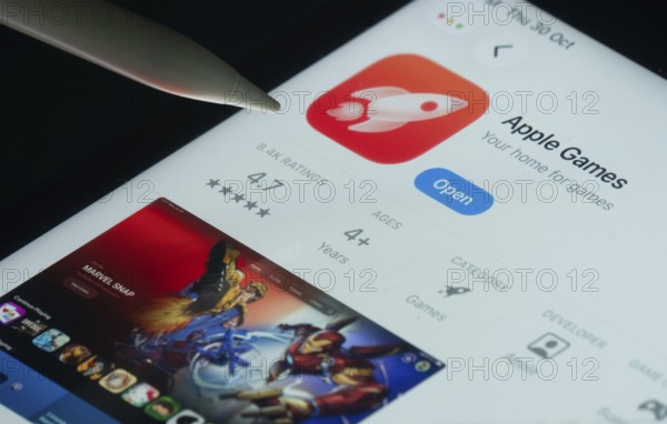 Dhaka, Bangladesh- 30 Oct 2025: Apple Games app on a iPad screen with a pen pointing at the install option