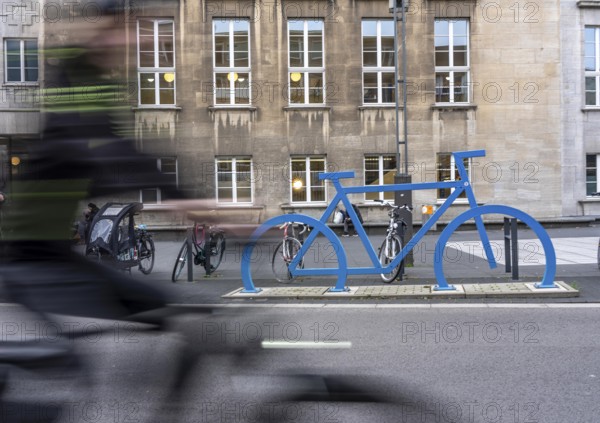 Bicycle parking spaces, with so-called leaning bars and a large blue bicycle silhouette, to make parking spaces visible at Bochum City Hall, North Rhine-Westphalia, Germany