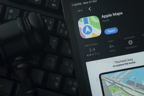 Dhaka, Bangladesh- 28 Oct 2025: An iPad displaying the Apple Maps app against a judge's gavel and dark keyboard background
