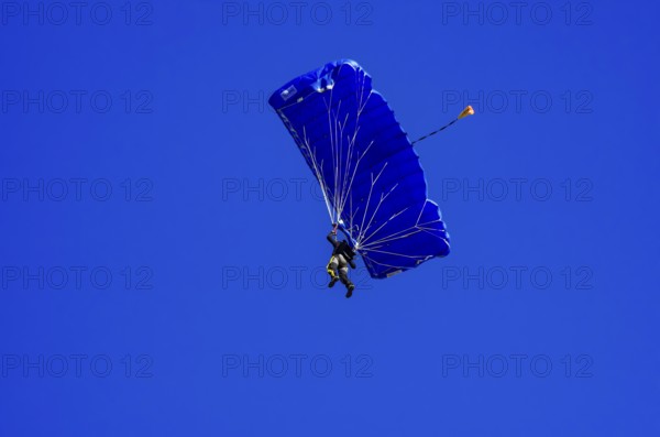 Skydivers during an aerial acrobatic performance as part of an air show at the Fliegerbergfest of the Rossfeld Luftsportverein in Metzingen-Glems, Baden-Württemberg, Germany, for editorial use only