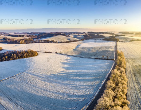 Bird Eye Perspective of Frost Covered Farmland. Seasonal Agricultural Scenery, winter and autumn scene, blue sky with golden light at sunrise, AI generated