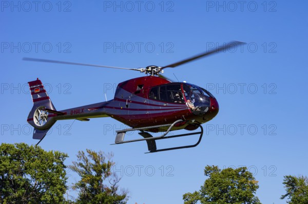 A Eurocopter EC 120B Colibri helicopter, D-HALX registration, during a flight demonstration as part of an air show on Rossfeld in Metzingen-Glems, Baden-Württemberg, Germany, for editorial use only