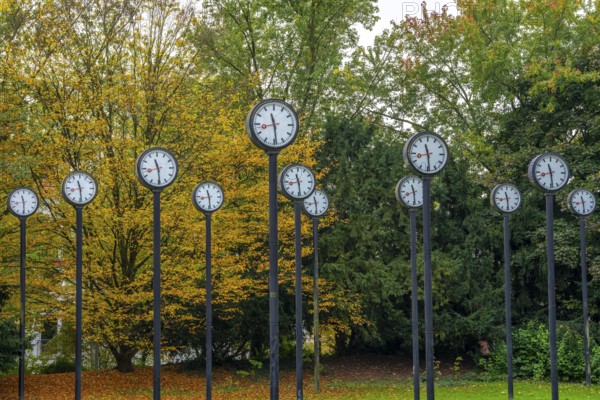 The art installation Zeitfeld in Volksgarten Park in Düsseldorf-Oberbilk, a total of 24 station clocks, on 6 meter high steel columns, have been running synchronously since 1987, artwork by Düsseldorf artist Klaus Rinke, symbol of time, time change, North Rhine-Westphalia, Germany