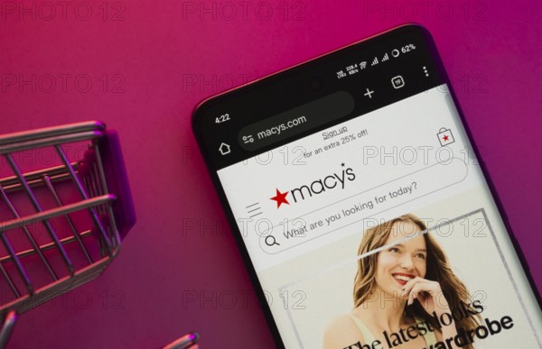 Dhaka, Bangladesh- 23 June 2025: A smartphone displaying the Macy's website with a shopping cart is shown on a vibrant background