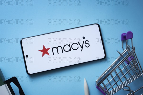 Dhaka, Bangladesh- 03 July 2025: Smartphone displaying Macy's logo with shopping cart on a blue background