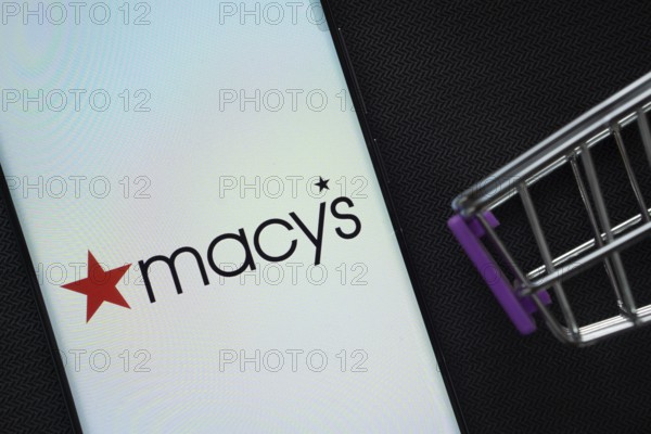 Dhaka, Bangladesh- 03 July 2025: A smartphone displaying the Macy's logo next to a miniature shopping cart on a background