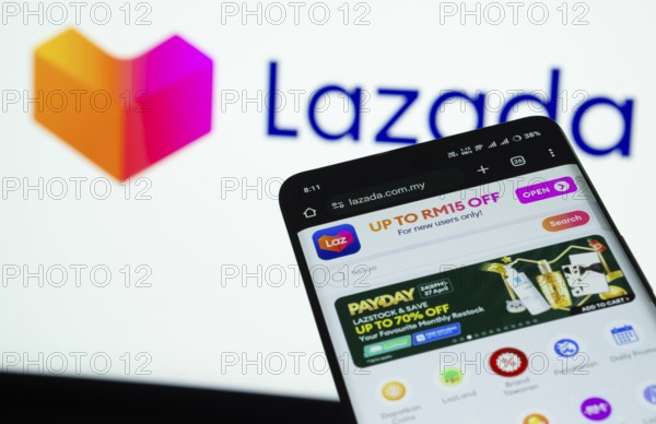 Dhaka, Bangladesh- 03 July 2025: Smartphone displaying Lazada web interface against Lazada logo background