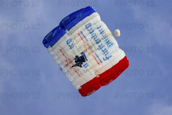 Two parachutists during an aerial acrobatic performance as part of an air show at the Rossfeld in Metzingen-Glems, Baden-Württemberg, Germany, for editorial use only