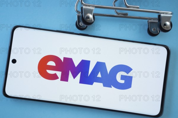 Dhaka, Bangladesh- 03 Oct 2025: Smartphone screen showing the Emag logo with shopping cart wheels on a blue background