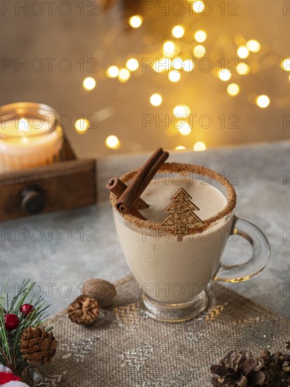 Creamy christmas eggnog featuring cinnamon sticks, nutmeg, and a festive christmas tree decoration