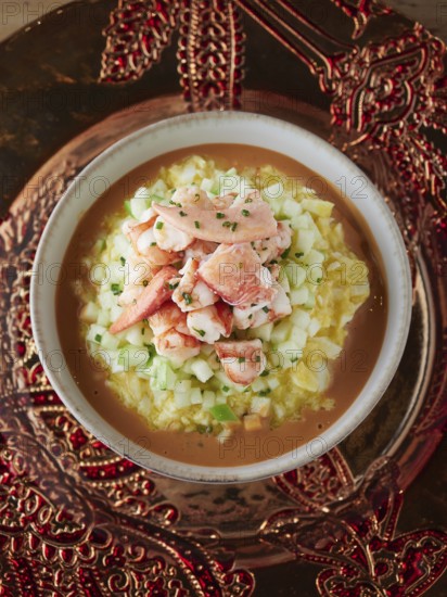 Delicious creamy seafood soup with fresh lobster pieces and cucumber