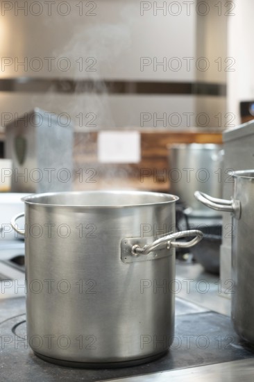 Commercial kitchen pot steaming on a restaurant stove, preparing food for cooking
