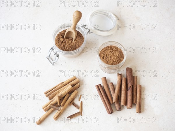 Various cinnamon forms, including ground powder in glass jars and different stick types
