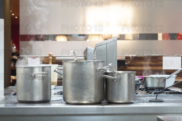 Steaming pots on a commercial stove in a professional kitchen, preparing food