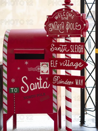 Festive red christmas mailbox and north pole signpost for sending letters to santa claus