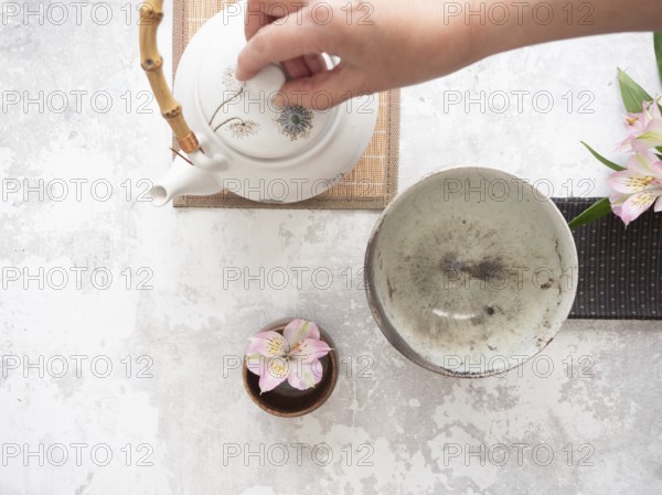 Teapot with bamboo handle and teacup ready for traditional tea ceremony preparation