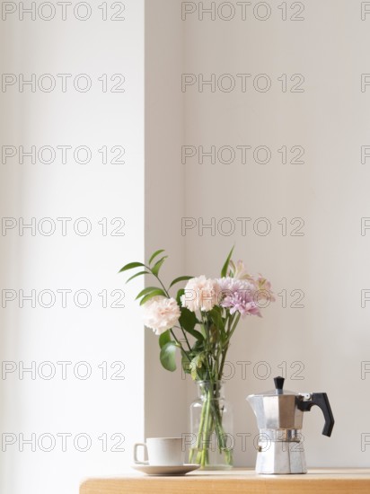 Enjoying a quiet moment with coffee and flowers, creating a cozy and relaxing atmosphere in a minimalist setting