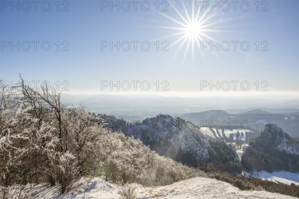 View over the hills and valleys from the mountain with hoarfrost on the branches in winter, Vápec, Horná Poruba, Slovakia